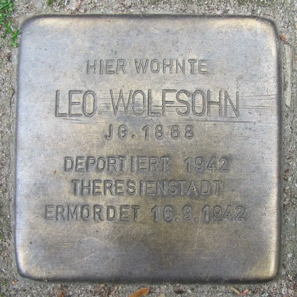 Das Bild zeigt einen verlegten Stolperstein Mut der Inschrift: "Hier wohnte Leo Wolfsohn, Jahrgang 1868. Deportiert 1942 nach Theresienstadt. Ermordet am 16.9.1942.